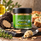 A jar of daRosario organic black truffle plant-based butter on a dark stone board with fresh and sliced black truffles, bread, herbs and buttered toast