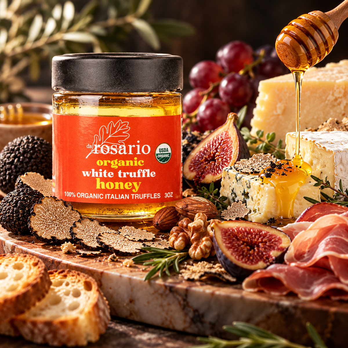 A jar of daRosario Organic White Truffle Honey on a charcuterie board with figs, brie, prosciutto, almonds, walnuts and grapes
