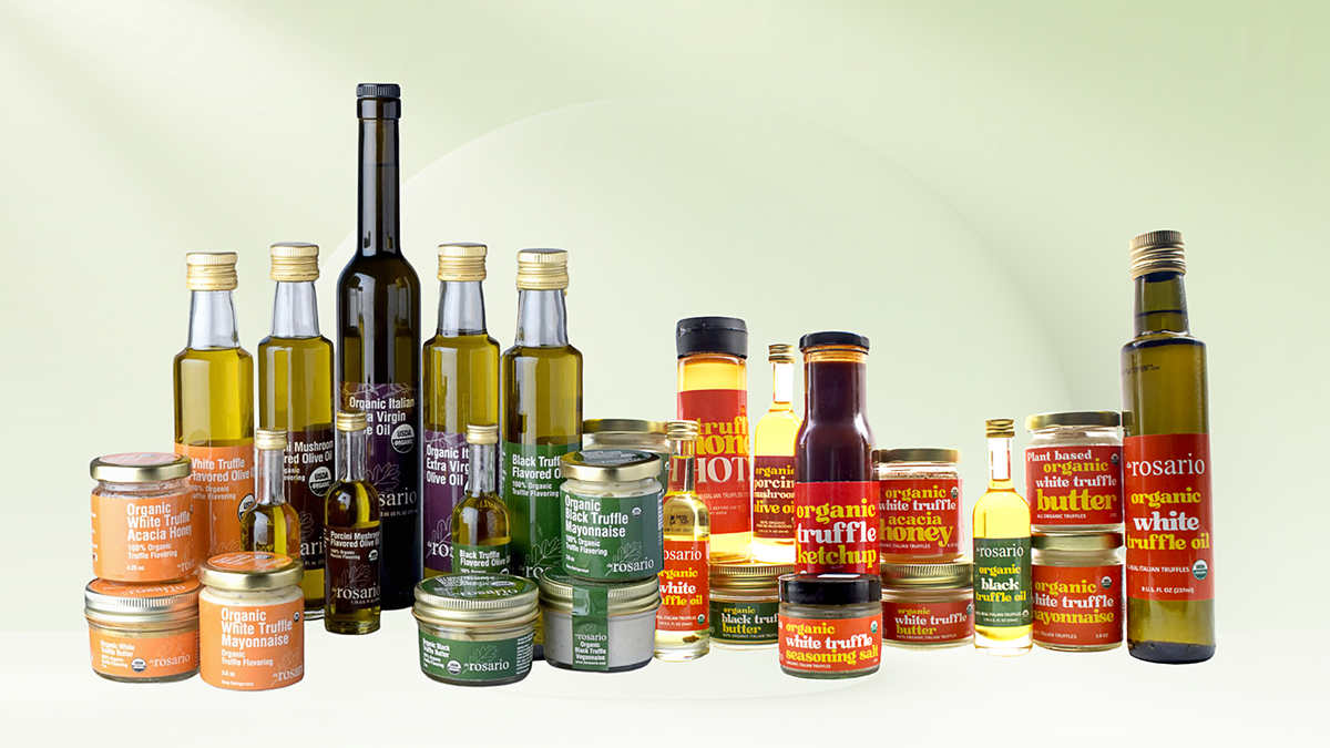 Assorted bottles and jars of olive oil and other products on a light green background